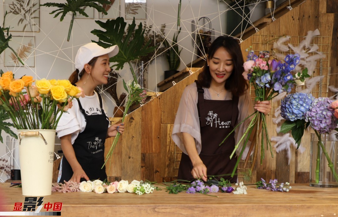 “昆明是鮮花的原產(chǎn)地，有亞洲最大的鮮切花交易市場，可以說具備開花店的天時地利；另外和很多女孩一樣，我從小也就有開花店的夢想！”說起當(dāng)初的決定，王黎媛說一是因?yàn)閴粝?，另外也跟昆明這個城市產(chǎn)花、賣花的“基因”有關(guān)。圖為王黎媛和同事在制作花束。新華網(wǎng) 周亞平/攝 念新洪/文