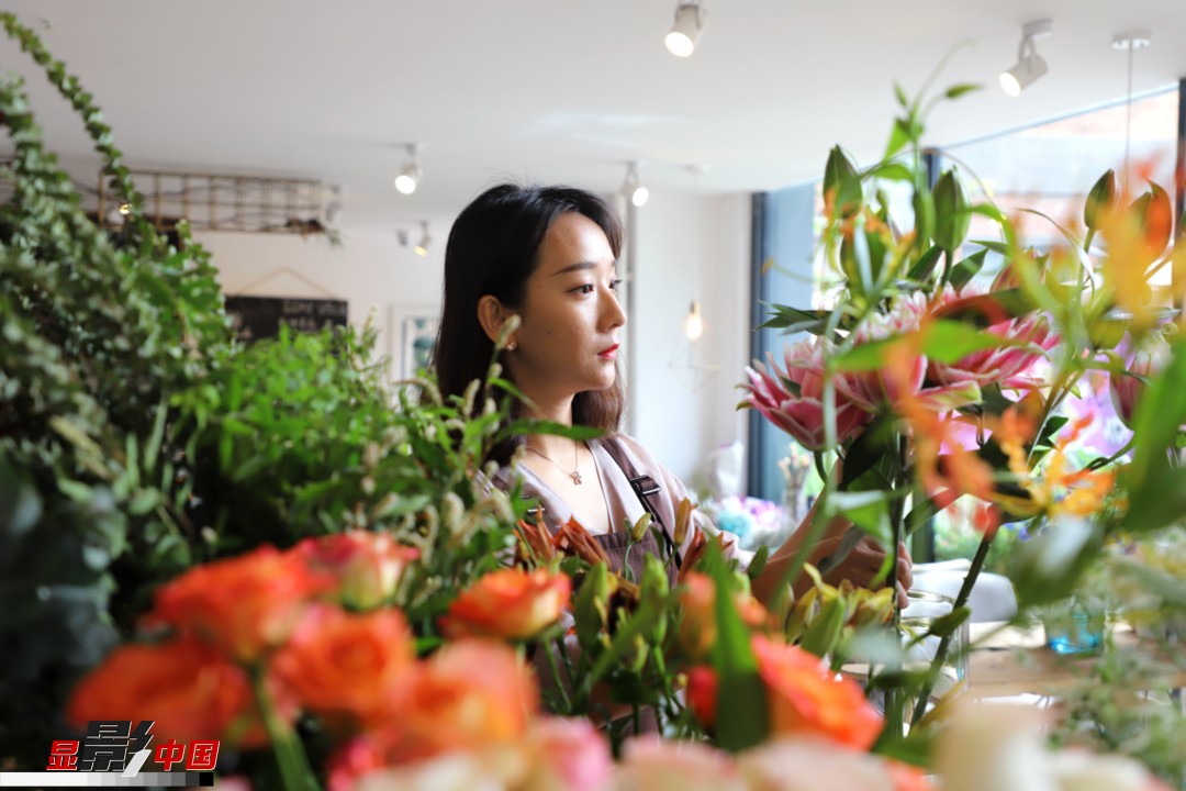 每天和花打交道是一個幸福的職業(yè)，但同時也充滿壓力和挑戰(zhàn)，“花在呈現(xiàn)給客人的那一瞬間是美好的，但前面的每一個步驟都是很辛苦的。”王黎媛說，花藝是最原始的手工藝產(chǎn)品，沒有辦法機(jī)械化、流程化和規(guī)模化，必須要用雙手一點(diǎn)點(diǎn)地賦予其生命和美感。圖為王黎媛在挑選制作花束的鮮花。新華網(wǎng) 周亞平/攝 念新洪/文
